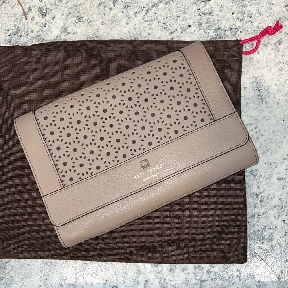 Kate Spade clutch in a taupe leather with laser cutout design.
